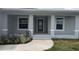 Inviting covered front porch featuring concrete walkway, gray stucco and white trim at 14464 Fort Myers Ave, Port Charlotte, FL 33981