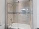 Well-lit bathroom featuring glass shower doors, toilet and built-in shelves at 5930 Anise Dr, Sarasota, FL 34238