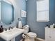 Stylish bathroom with a round mirror, pedestal sink, and blue walls creates a serene space at 5930 Anise Dr, Sarasota, FL 34238