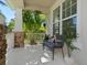 Relaxing covered porch with seating, stone accents, and view of tropical foliage at 5930 Anise Dr, Sarasota, FL 34238