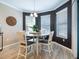Dining area with a round table, dark accent walls, and natural light from multiple windows at 5930 Anise Dr, Sarasota, FL 34238