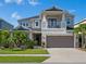 Two-story home with neutral paint, balcony, manicured lawn and tropical landscaping at 5930 Anise Dr, Sarasota, FL 34238