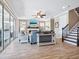 Open-concept living room featuring a fireplace, wood-look tile flooring, and access to a staircase at 5930 Anise Dr, Sarasota, FL 34238