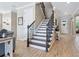 Elegant staircase with wooden handrails, iron spindles, and a view of the entry foyer at 5930 Anise Dr, Sarasota, FL 34238