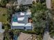 Aerial view of coastal home featuring screened in pool and well-maintained yard with mature trees at 705 Armada N Rd, Venice, FL 34285
