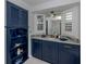 Bathroom showcasing blue vanity with marble countertop and a view to the soaking tub at 705 Armada N Rd, Venice, FL 34285