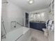Elegant bathroom with modern fixtures, a soaking tub, and navy blue cabinets for a luxurious feel at 705 Armada N Rd, Venice, FL 34285