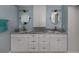 Updated bathroom featuring double sinks with marble countertops, white cabinets, and modern fixtures at 705 Armada N Rd, Venice, FL 34285