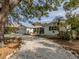 Charming single-story home featuring a crushed shell driveway, well-manicured landscaping and a cozy front porch at 705 Armada N Rd, Venice, FL 34285