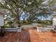 Expansive front yard with mature trees and a brick walkway leading to the home's entrance at 705 Armada N Rd, Venice, FL 34285