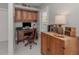 This home office features custom cabinets, a wood desk, an ergonomic chair, and natural light through shuttered windows at 705 Armada N Rd, Venice, FL 34285