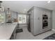 Kitchen with gray cabinets, stainless steel appliances, white countertops, and a large window with shutters at 705 Armada N Rd, Venice, FL 34285