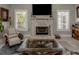 Cozy living room with a stone fireplace, plantation shutters, and comfortable seating at 705 Armada N Rd, Venice, FL 34285