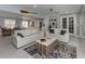 Open living room into eat-in kitchen area, featuring white couches, tile flooring, and modern décor at 705 Armada N Rd, Venice, FL 34285
