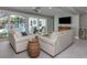 Bright living room with large sliding doors to the pool, white couches, and tile flooring at 705 Armada N Rd, Venice, FL 34285