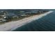 Stunning aerial view of white sand beach and oceanfront coastline with lush vegetation, waterfront homes, and tranquil blue waters at 107 Louella Ln, Nokomis, FL 34275