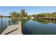 Scenic view of a peaceful dock area with calm waters and lush green trees in the background at 107 Louella Ln, Nokomis, FL 34275