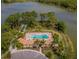 Aerial view of community pool and tennis courts surrounded by lush landscaping, located on a peninsula on the lake at 11601 Parrotfish St, Venice, FL 34292