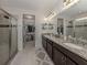 Beautiful primary bathroom with double vanity, granite counters, tiled shower, and walk-in closet at 11601 Parrotfish St, Venice, FL 34292