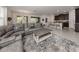 Open-concept living room features a modern sectional sofa, coffee table, and access to kitchen at 11601 Parrotfish St, Venice, FL 34292