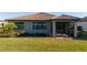Home's backyard with a well maintained lawn and a covered screened lanai at 13164 Rinella St, Venice, FL 34293