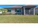 Home's backyard with a well maintained lawn and a covered screened lanai at 13164 Rinella St, Venice, FL 34293