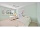 Bright bedroom with two twin beds, white shutters, and a ceiling fan, creating a fresh and inviting space at 1348 Reserve Dr, Venice, FL 34285