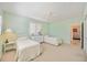 Airy bedroom featuring twin beds, ceiling fan, and a glimpse into an adjacent room, offering comfortable living at 1348 Reserve Dr, Venice, FL 34285