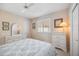 Bedroom with a white dresser, plantation shutters, ceiling fan, and a comfortable queen bed, providing relaxation at 1348 Reserve Dr, Venice, FL 34285