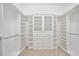 Spacious walk-in closet with custom shelving, cabinetry and carpet floors at 1348 Reserve Dr, Venice, FL 34285
