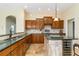 Well-lit kitchen with wooden cabinets, tiled backsplash, and a center island with wine fridge at 1348 Reserve Dr, Venice, FL 34285