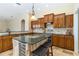 Spacious kitchen with wood cabinets, tiled floor, and a center island with seating at 1348 Reserve Dr, Venice, FL 34285