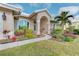 Close-up of the home's entrance with manicured landscaping and a paved walkway at 1558 Belfry Dr, Venice, FL 34292