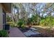 Backyard featuring a garden bed, concrete bench, and lush tropical landscaping at 201 Auburn Woods Cir, Venice, FL 34292