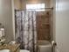 Bathroom showcasing a granite countertop and shower-tub combo with decorative tile at 201 Auburn Woods Cir, Venice, FL 34292