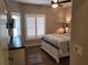 Bedroom featuring white shutters, wood floors, and a ceiling fan with light at 201 Auburn Woods Cir, Venice, FL 34292