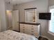 Bedroom with a dresser, mirror, and wall-mounted TV at 201 Auburn Woods Cir, Venice, FL 34292