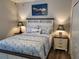 Bedroom with a decorative headboard, lamps, and a boat painting above the bed at 201 Auburn Woods Cir, Venice, FL 34292