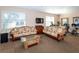 Inviting clubhouse seating area with sofas, TV, and exercise equipment in the background at 201 Auburn Woods Cir, Venice, FL 34292