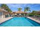 Beautiful community pool area with inviting blue water, lounge chairs, and lush landscaping at 201 Auburn Woods Cir, Venice, FL 34292