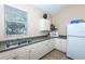Functional kitchenette with appliances, storage, and view to the outdoors at 201 Auburn Woods Cir, Venice, FL 34292
