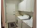 Laundry room with a washer, dryer, utility sink, and white cabinets at 201 Auburn Woods Cir, Venice, FL 34292
