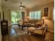 Cozy living room features stylish furniture, wood flooring, and a sliding door with a backyard view at 201 Auburn Woods Cir, Venice, FL 34292