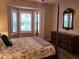 Main bedroom featuring a four-poster bed, shuttered windows, and a decorative mirror at 201 Auburn Woods Cir, Venice, FL 34292