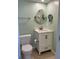 Bathroom features a white vanity, round mirror, and light green walls at 232 Saint Augustine Ave # 704, Venice, FL 34285