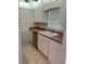 Traditional kitchen with white cabinets, stainless steel appliances, and patterned wallpaper at 232 Saint Augustine Ave # 704, Venice, FL 34285