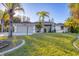 Charming single-story home featuring a two-car garage, well-maintained lawn, and tropical landscaping at 2899 Ensenada Ln, North Port, FL 34286