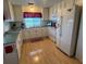 Well-lit kitchen featuring white appliances, ample counter space, and laminate wood flooring at 356 Longwood Dr, Venice, FL 34285