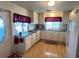 Bright kitchen featuring white cabinetry, modern appliances, and wood laminate flooring at 356 Longwood Dr, Venice, FL 34285