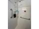 Shower featuring white tile, shower head, built-in shelves, and conveniently placed safety grab bars at 356 Longwood Dr, Venice, FL 34285